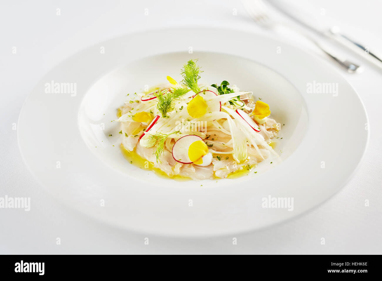 Ceviche pesce crudo Perù Tom Aiken rafano agrumi limone lime frutti di mare bianco piatto bianco panno da tavolo tagliato fuori fresco zesty Michelin star chef Foto Stock