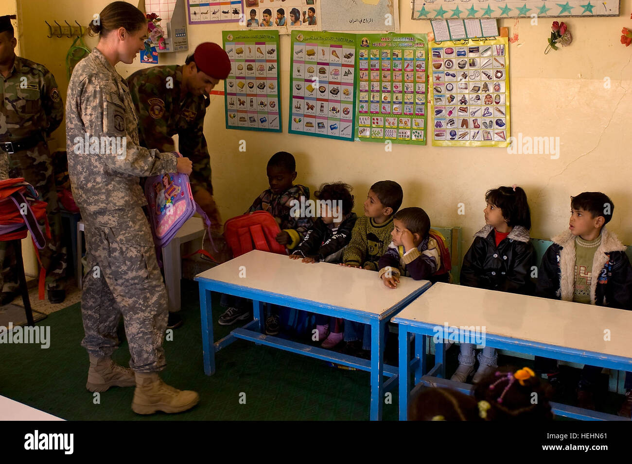 Stati Uniti Esercito Cpt. Charcillea Barrett, Comandante, XXI Polizia Militare Company (airborne), Fort Bragg, N.C., distribuisce nuovi zaini per iracheno studenti elementari in Al Quartiere Hayyaniah, di Bassora, in Iraq, Dic 23. La missione a Bassora 138379 Foto Stock