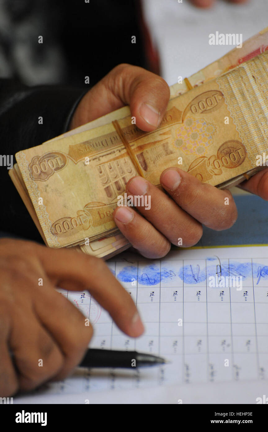 Un governo iracheno gazzetta contiene una pila di dinari Iracheni durante un figli dell'Iraq in caso di pagamento a gennaio 18 in corrispondenza del giunto di sicurezza Beladiyat stazione nel nuovo distretto di Bagdad orientale di Baghdad. Figli di Iraq pagato lo stipendio mensile 146917 Foto Stock