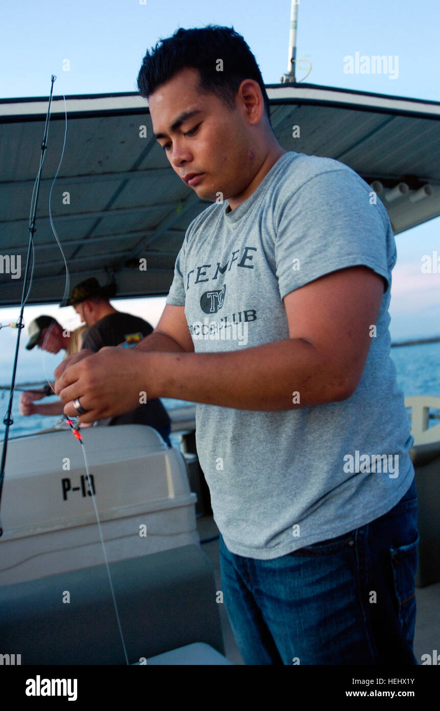 GUANTANAMO Bay a Cuba - una marina Sottufficiali di seconda classe, con il Joint Medical Group, esche il suo gancio durante una notte di pesca Tour Liberty, 7 maggio 2009. Il Liberty Tour Il Programma prevede attività a poco o nessun costo per non accompagnati dazio attivo Joint Task Force Guantanamo Troopers. JTF Guantanamo conduce al sicuro, umano, legale e trasparente di cura e custodia dei detenuti , compresi quelli condannati dalla commissione militare e quelli ordinati rilasciato. La JTF conduce la raccolta di intelligence, analisi e diffusione per la tutela dei detenuti e il personale che lavora in JTF Guantanamo faci Foto Stock