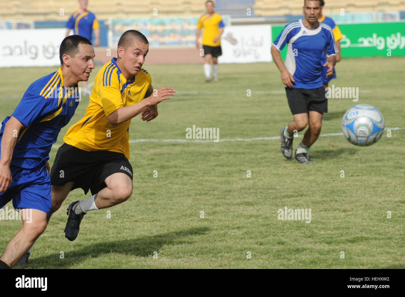 Stati Uniti Il personale dell'esercito Sgt. Carlos Vasquez (sinistra) da Los Angelos, California, della sede centrale e sede società, 3° Brigata Team di combattimento, ottantaduesima Airborne Division, corre verso il pallone come vola attraverso l'aria durante un giunto da Iraq e Stati Uniti ultima partita del torneo a Sha'ab stadium in Eastern Baghdad, Iraq, il 23 maggio 2009. Stati Uniti I soldati della terza Brigata Team di combattimento, ottantaduesima Airborne Division e nazionale irachena sono poliziotto che partecipano a un pubblico di torneo di calcio sponsorizzato dall'unità FC Organizzazione. Torneo di Calcio a Bagdad 176528 Foto Stock