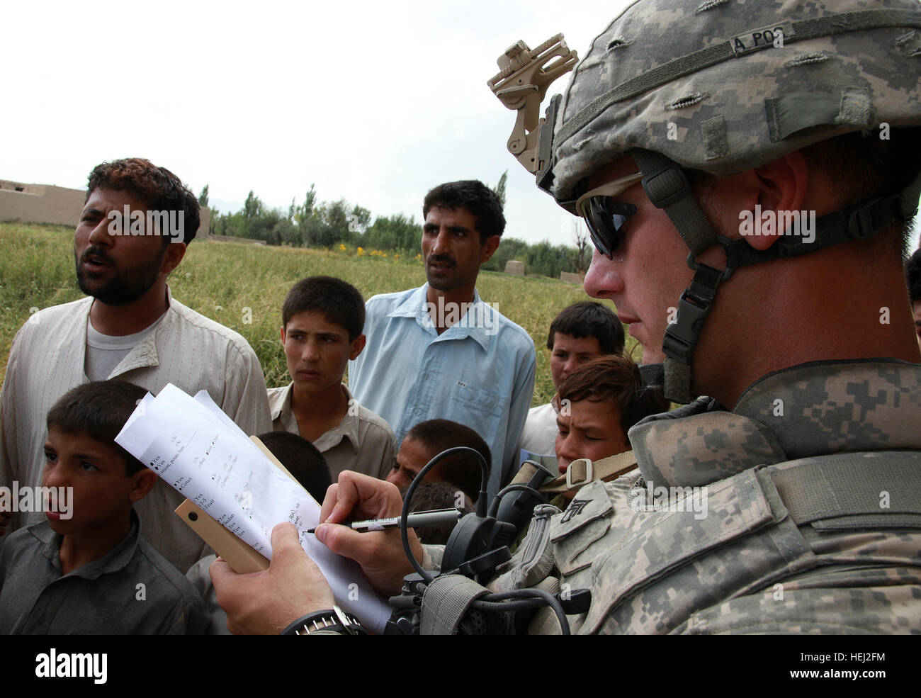 Stati Uniti Il personale dell'esercito Sgt. Derek Smith, assegnato a 118 Polizia Militare (Airborne) azienda, 3° Brigata truppe speciali battaglione, decimo Montagna divisione, interviste locali afghani circa il modo in cui molte scuole, cosa essi crescono e se hanno delle strutture mediche disponibili nel loro villaggio nella provincia di Logar, Afghanistan, Sett. 1. Stati Uniti, forze afghane consegnare forniture scolastiche nella provincia di Logar 202298 Foto Stock