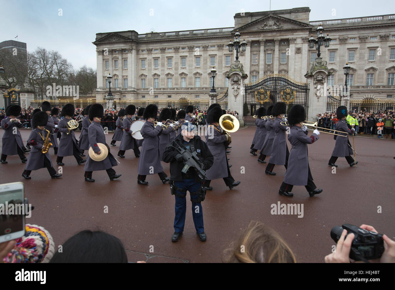 Polizia armata fornire protezione durante il cambio della guardia al di fuori Buckingham Palace, London, England, Regno Unito Foto Stock