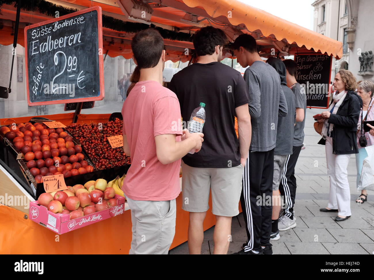 Le persone acquistano frutta fresca ad un'estate all'aperto di stallo del mercato in Germania. Foto Stock