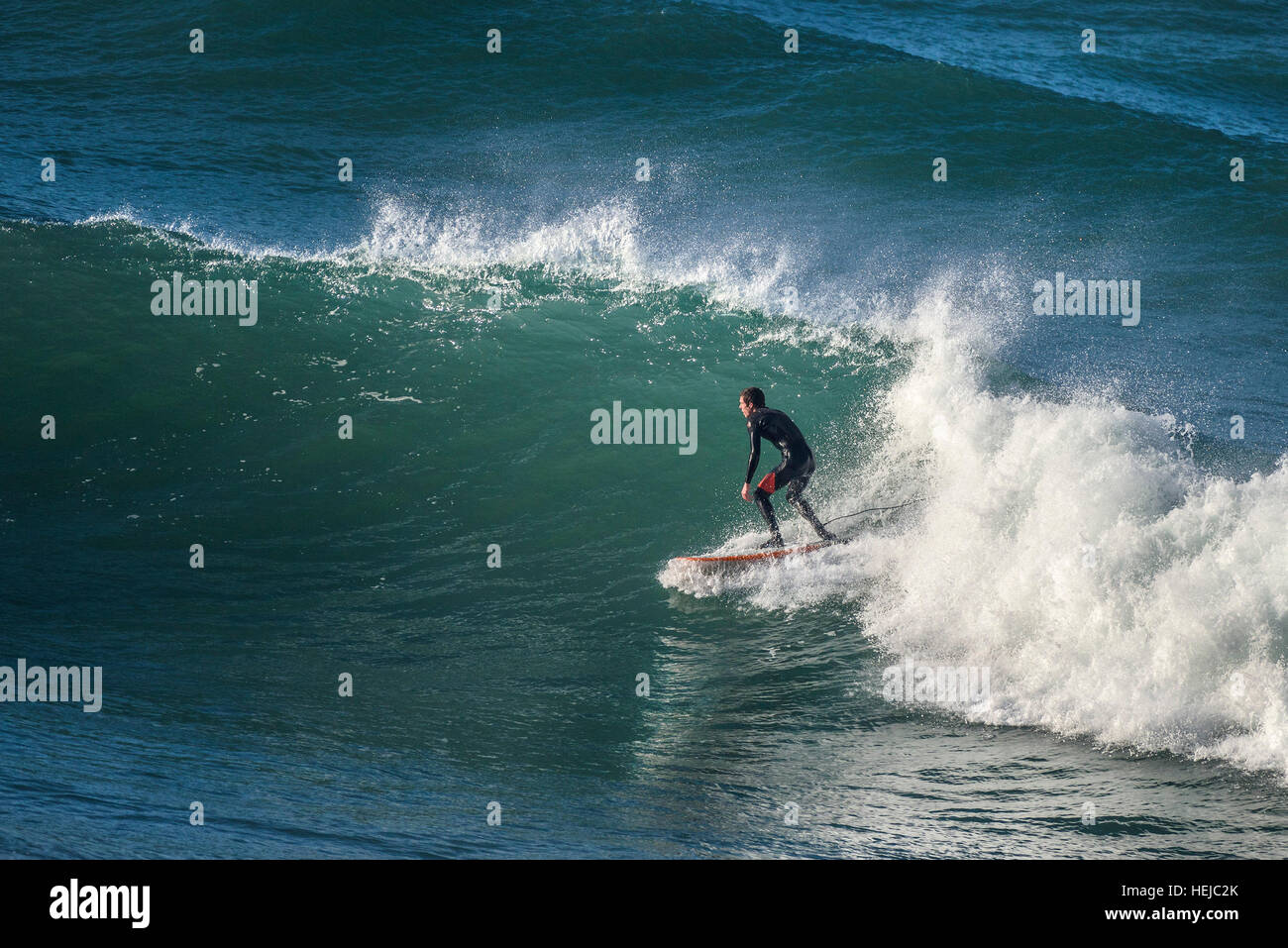 Un surfista cavalca un big wave a poco Fistral in Newquay; Cornovaglia Foto Stock