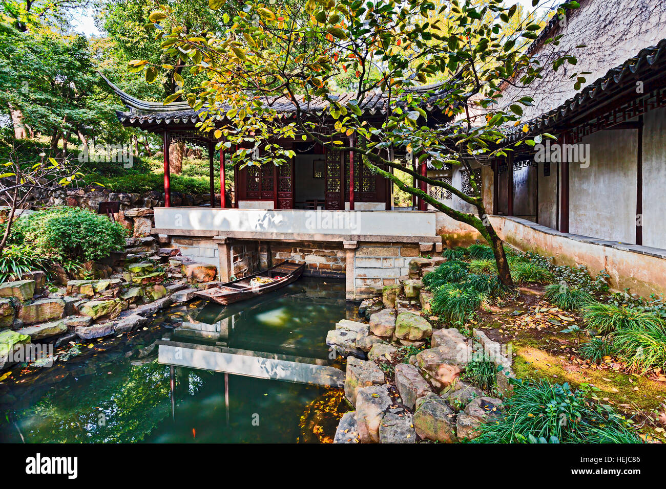 Cinese tradizionale giardino formale in Nanjing con piccolo canale di acqua, barca flottante , il classico padiglione e salutare gli alberi. Foto Stock