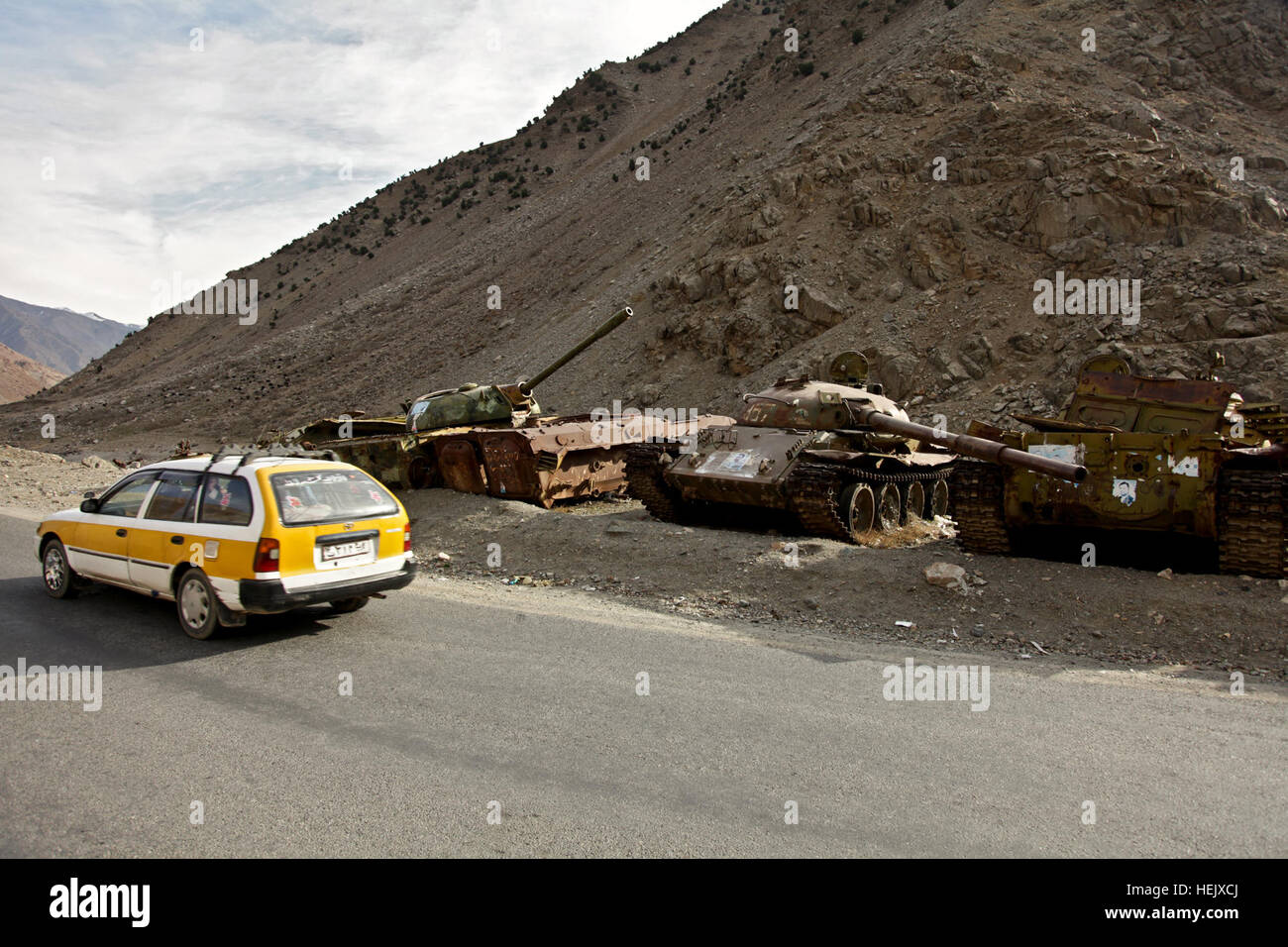 Un taxi afgano unità nella parte anteriore dei vecchi carri armati russi che sono retaggio delle invasione sovietica dell'Afghanistan nel Panjshir Provincia, Afghanistan a gennaio 02, 2010. (U.S. Esercito foto di Sgt. Teddy Wade/RILASCIATO) Afghan Taxi in Panjshir Provincia Foto Stock