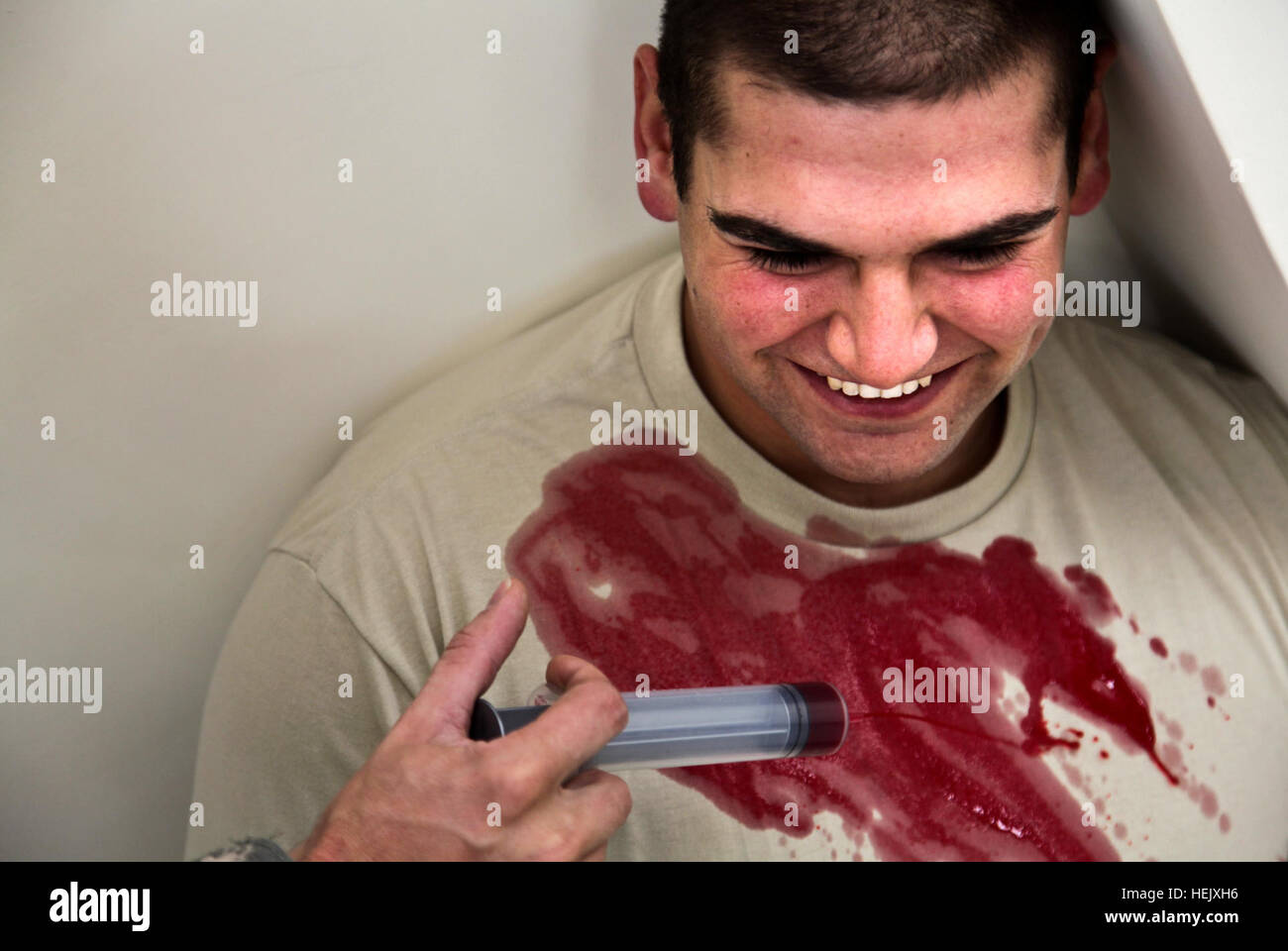 Stati Uniti Army Spc. Nick Ferrara, 24, assegnato al 410 Polizia Militare Company, fuori di Fort Hood in Texas, ride come un compagno soldato versa sangue finto oltre la sua t-shirt durante uno scenario di addestramento con la polizia nazionale afgana officer presso la stazione di polizia nel quartiere Shutol del Panjshir Provincia, Afghanistan, gennaio 6. Polizia nazionale afgana 237815 di formazione Foto Stock