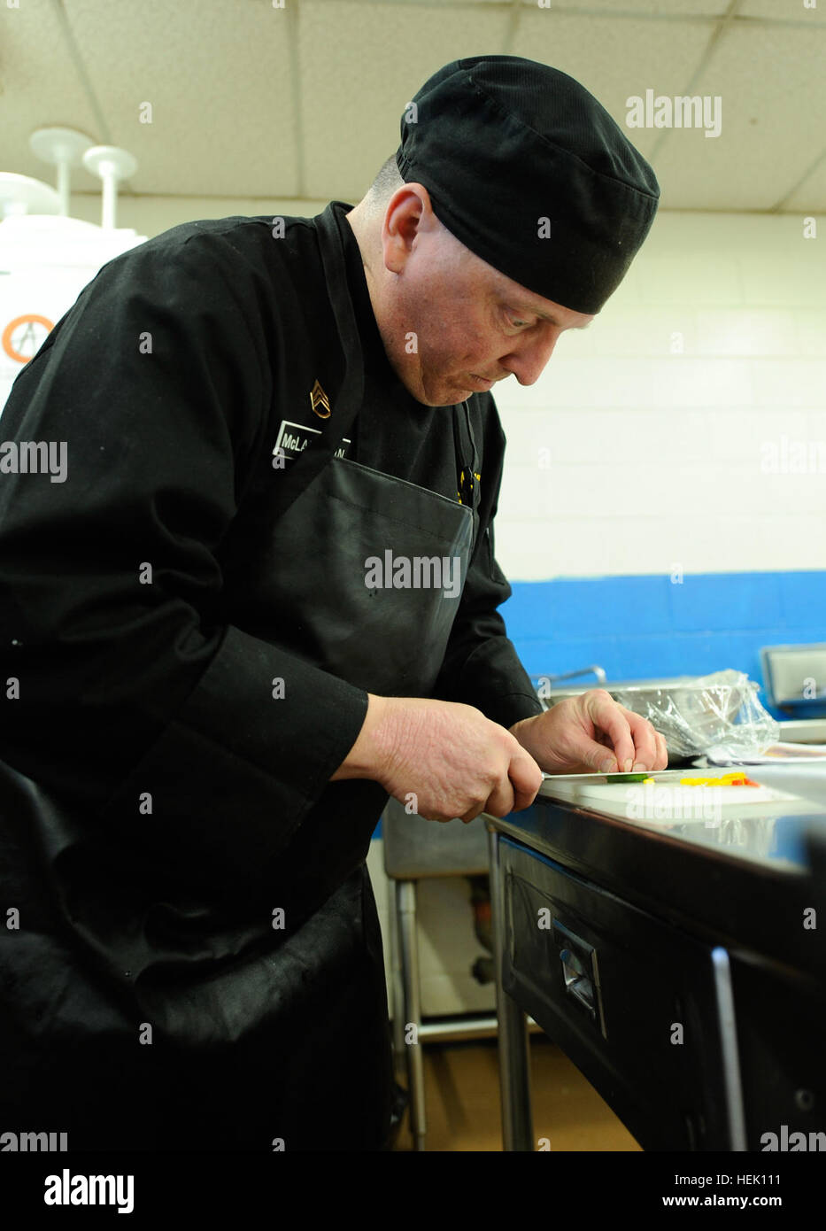 Esercito personale di riserva Sgt. Jeffrey McLauglin fette peperoni per la visualizzazione della tabella nel team di cucina al trentacinquesimo U.S. Esercito di Arti Culinarie di concorrenza a Fort Lee, Va., lunedì 8 marzo. McLaughlin, da Osage, Iowa, è assegnato al 103 Expeditionary supporto comando basato a Des Moines, Iowa. La visualizzazione della tabella sarà impostato nel campo Post House e incorpora un 12-piede da 12 piedi di display che sarà caratterizzata da una varietà di elementi da includere buffet freddo per vassoi, Centritavola, petit fours, lungo con marizpan, fondente, sego, cioccolato e pasta di sale sculture. Dietro le quinte con th Foto Stock