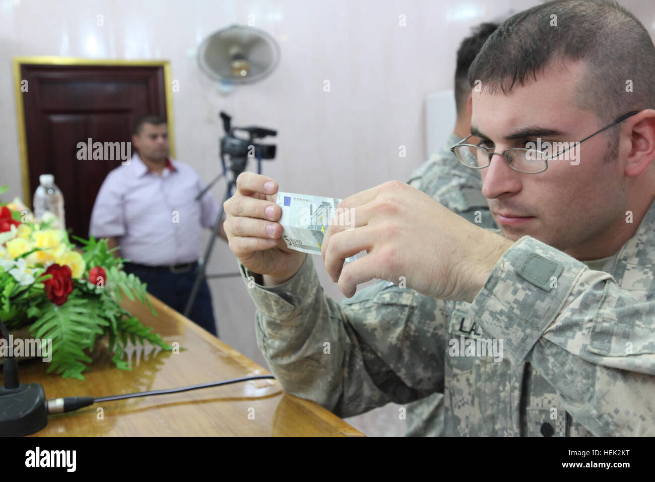 Stati Uniti Army Spc. David Lalonde dal 318Operazioni psicologiche azienda esamina cinque euro bill come parte delle misure anti-contraffazione a livello provinciale Joint Coordination Center di Nassiriya, Iraq, 25 aprile. Lalonde prepara una classe per la polizia irachena per imparare a rilevare la contraffazione di denaro. Classe sulla contraffazione di denaro 274449 Foto Stock