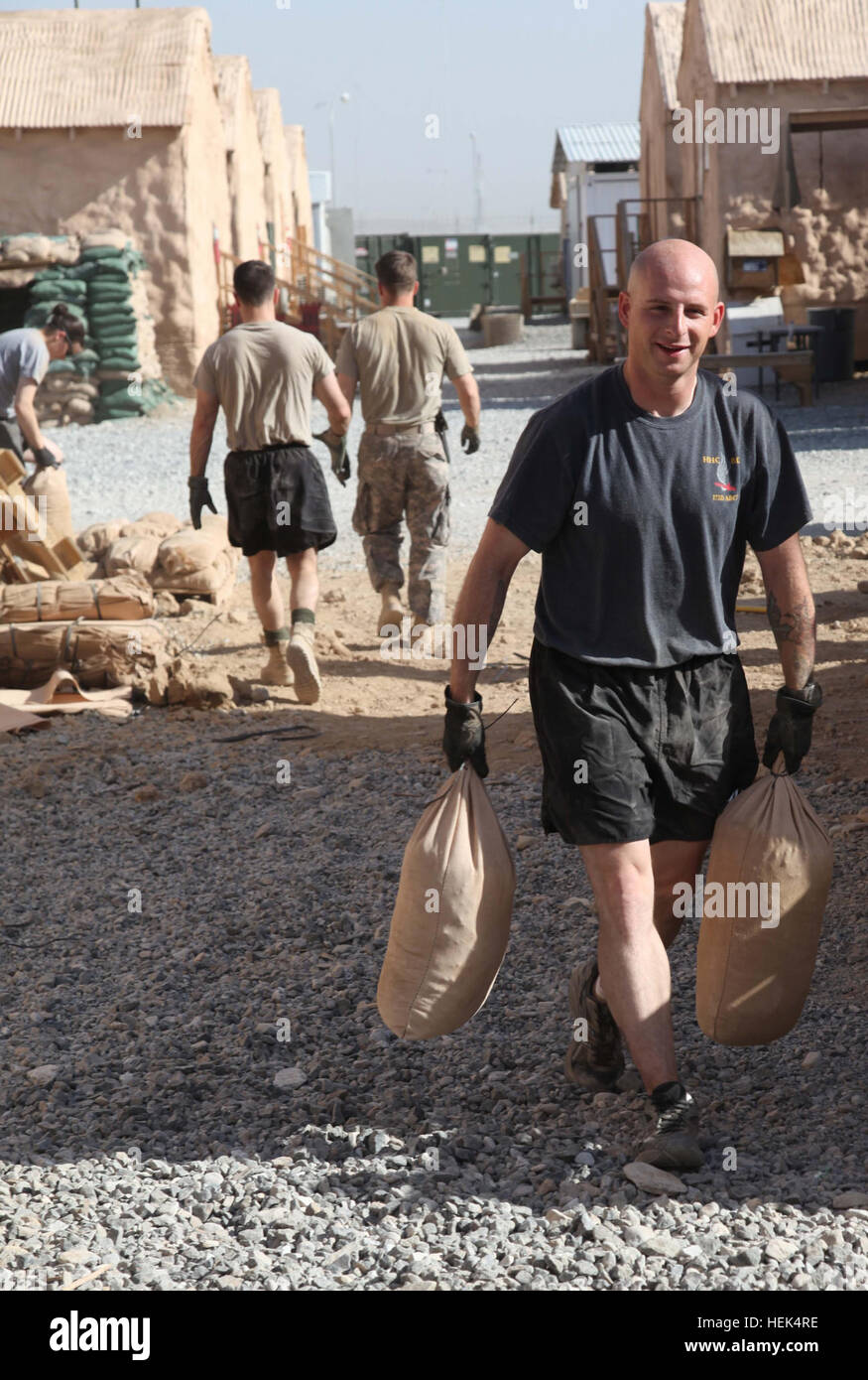 Stati Uniti Army Sgt. Giuseppe Niggemann, tattiche di operazione di informazione non ufficiale incaricato dal 173rd Airborne Brigade Combat Team, si sposta di sacchi di sabbia per costruire un muro per aumentare la sicurezza di marcia avanti la base operativa per la mattina presto allenamento fisico a inoltrare una base operativa gambo, provincia di Logar, Afghanistan luglio 18. Soldati riempire sacchi di sabbia per esercizio 300657 Foto Stock