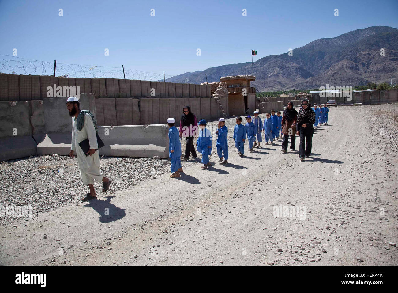 I membri di Stati Uniti Esercito di supporto culturale Team 2 (CST) a piedi con gli studenti afghani attraverso la voce del punto di controllo del combattimento avamposto Penich, Kunar Provincia, Afghanistan, 14 maggio 2011. Gli studenti di Tanar scuola primaria sono stati invitati a partecipare ad una giornata di film che è stato ospitato dal CST con l'intento di instaurare un rapporto di fiducia con il Khas Kunar District Community. (U.S. Esercito foto di PFC. Benjamin Tuck/Non rilasciato) Operazione Enduring Freedom 403506 Foto Stock