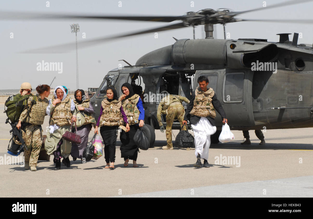 Le donne afghane che frequentano una femmina di sicurezza shura alla forza internazionale di assistenza alla sicurezza del comando regionale del quartier generale del Nord insieme con i membri di RC a nord di innesto femmina Team partono a UH-60un Black Hawk elicottero dalla Task Force Lobos, 1° aria brigata di cavalleria, 1a divisione di cavalleria, 21 giugno. Due gli equipaggi degli aerei da TF Lobos ha trasportato i partecipanti e i membri del FET da altre basi di coalizione nel nord dell'Afghanistan. Questo è stato il primo shura ospitato presso il Comando regionale di livello per concentrarsi sulle donne afghane. (U.S. Esercito foto di Sgt. Richard Wrigley) RC Nord sicurezza femmina shura 419732 Foto Stock