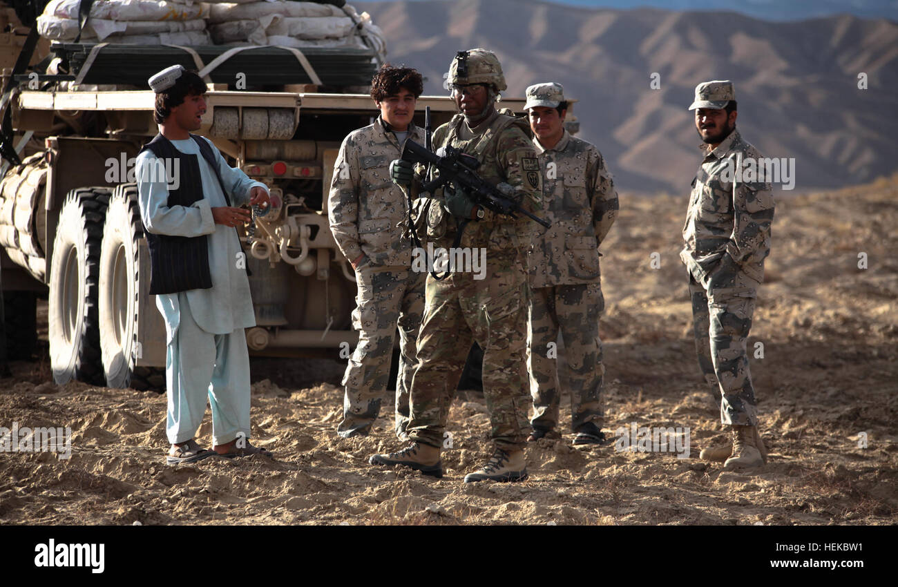 Un U.S. Soldato dell'esercito combinato dei Task Force Viper conversa con Afghanistan Polizia di frontiera vicino Wanake Valley, provincia di Kandahar, Afghanistan, Sett. 3, 2011. CTF stava conducendo il funzionamento Viper Slam in cui i soldati sono andato attraverso una ricerca e sequestro per individuare i membri dei talebani e i loro sostenitori in Valle Wanake. (Foto: Spc. Kristina Truluck, 55th Signal Company) Funzionamento Viper Slam 110903-A-VB845-029 Foto Stock
