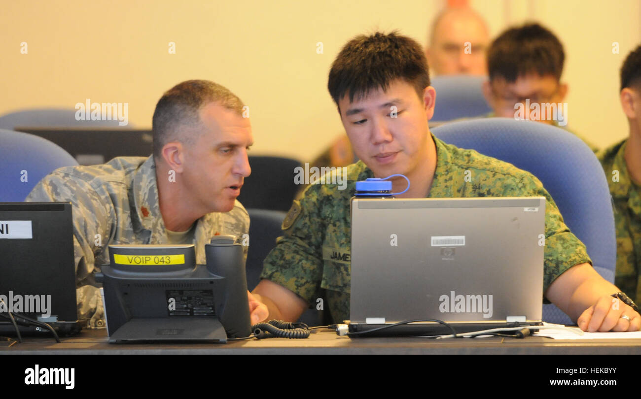 Il Mag. James Mitchell, l'aria funzionario di collegamento con i 116Air Control Squadron, Oregon Air National Guard e il suo omologo Cpt. James Kee con la Singapore Forze Armate review aria informazioni di supporto durante la tigre balsamo war game al Pasir Laba Camp, Singapore, luglio 25. Stati Uniti e SAF uniti insieme per due settimane a luglio per Tiger Balm '11, un bilaterale annuale di esercizio. Gli eserciti di condividere le strategie militari e le tecniche della difesa, del reato e operazioni mentre edificio militare e relazioni culturali. Quest'anno la messa a fuoco è stata offesa, della difesa e delle operazioni. (U.S. Esercito foto di Foto Stock
