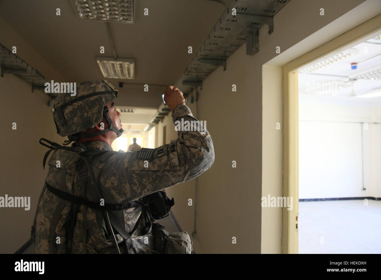 Gli ingegneri strutturali civili dell'esercito degli Stati Uniti ispezionano una scuola di formazione per insegnanti di nuova costruzione a Charikar, provincia di Parwan, Afghanistan, valutando l'integrità strutturale e documentando le carenze prima di aprire l'edificio per l'uso. Foto Stock