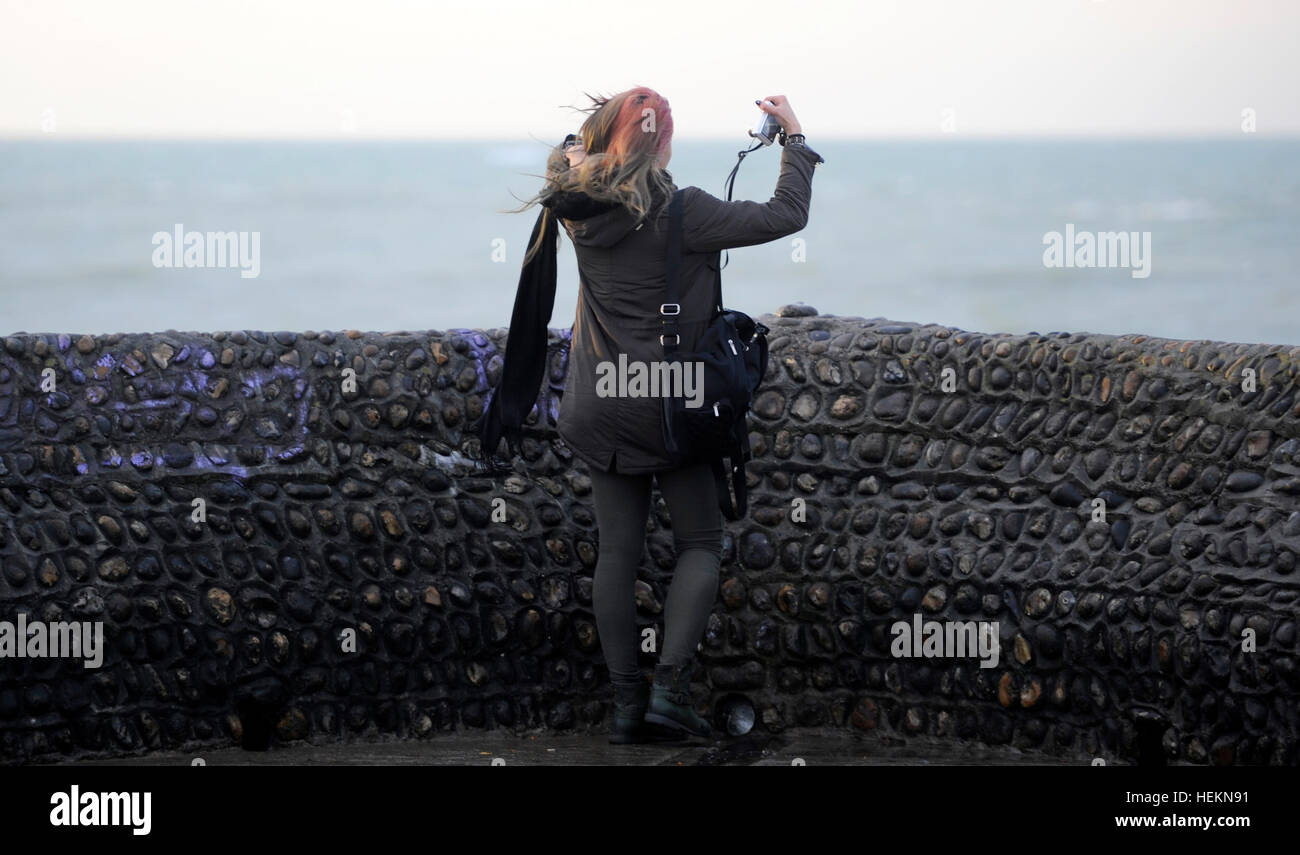Brighton Sussex Regno Unito 23 dicembre 2016 - una giovane donna assume un selfie photogrpah sul lungomare di Brighton come tempesta barbara si aspetta di colpire la Gran Bretagna più tardi oggi con venti previsione di raggiungere fino a 90 mph in Scozia fotografia scattata da simon dack credito: simon dack/alamy live news Foto Stock