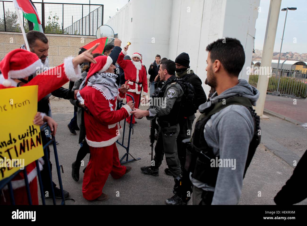 Betlemme, West Bank. 23 Dic, 2016. Gli uomini palestinesi travestiti da Santa Claus per prendere parte a una protesta contro Israele la controversa barriera di separazione in Cisgiordania città di Betlemme, a Dic. 23, 2016. © Mamoun Wazwaz/Xinhua/Alamy Live News Foto Stock