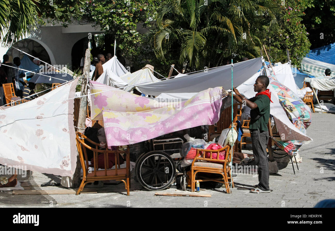 Petionville, Florida, Stati Uniti d'America. 23 Dic, 2016. 011610 (Acque Lannis/Palm Beach post) PETIONVILLE, HAITI - un uomo regola la sua tenda di fortuna nel parcheggio al di fuori della Villa Creole hotel. Il sistema SCR 2573 © Lannis acque/Palm Beach post/ZUMA filo/Alamy Live News Foto Stock