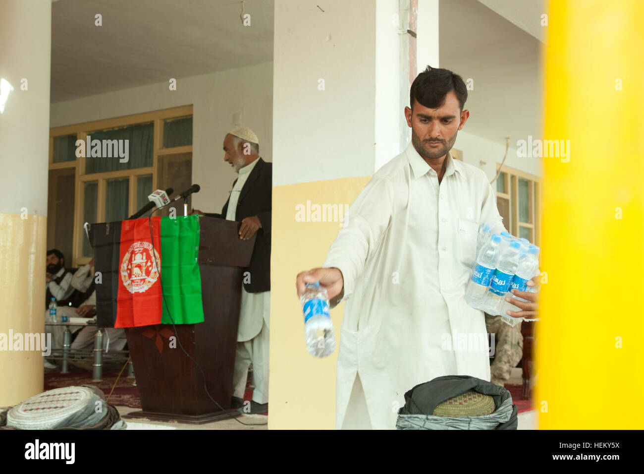 Un lavoratore presso il centro distretto distribuisce acqua ai partecipanti di una shura, Zharay distretto, provincia di Kandahar, Afghanistan, 5 ottobre. La shura è tenuto a discutere di governance del distretto. Shura al centro distretto 111005-A-QD683-126 Foto Stock