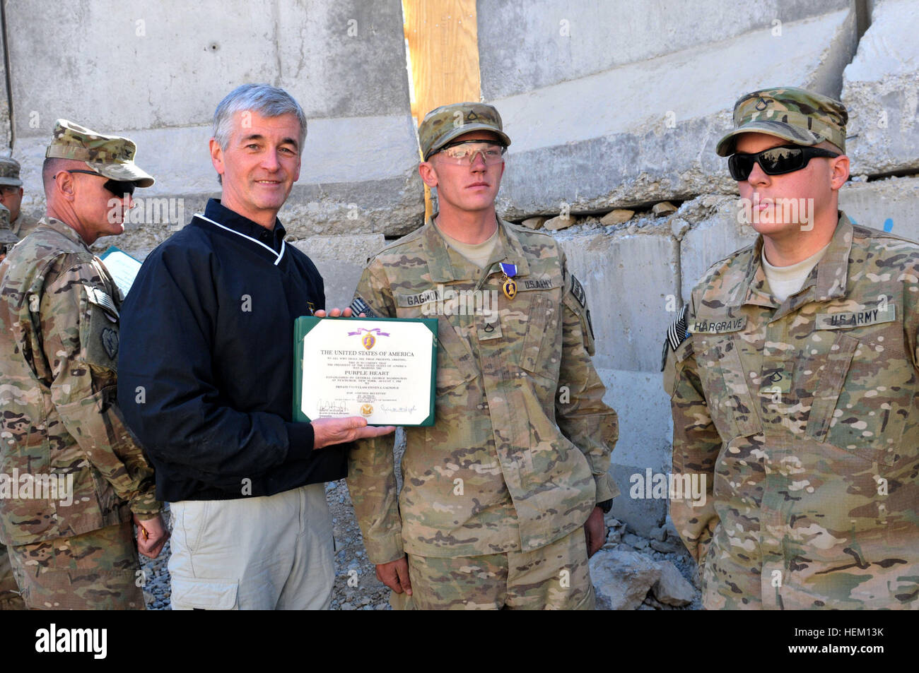 Segretario dell'esercito John M. McHugh presenta il cuore viola di PFC. Steven Gagnon, un fante con 1° Battaglione, quinto reggimento di fanteria, 1° Stryker Brigade Combat Team, XXV divisione di fanteria, e un portiere, Maine, nativo, durante una cerimonia a inoltrare una base operativa Masum Ghar dic. 14. Segretario dell'esercito visite Panjwa'i, Afghanistan 111214-A-AX238-004 Foto Stock