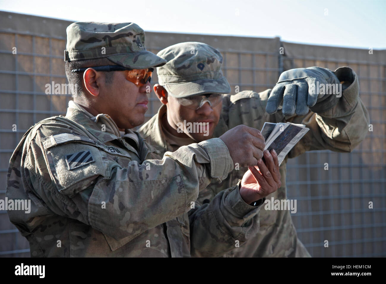 Stati Uniti Il personale dell'esercito Sgt. Miguel Peña, da Queens, sinistra e SPC. Marquez Williams, dalle corna, California, destra, assegnato a seconda del plotone, una compagnia di fanteria 141, 3-1 Armor Division, Fort Bliss, Texas, guardare su una mappa per stendere una tabella di sabbia per un prossimo briefing al funzionamento in avanti codolo di base, provincia di Logar, Afghanistan, Dic 30, 2011. Operazione Mongoose nella provincia di Logar 111230-A-BZ540-002 Foto Stock