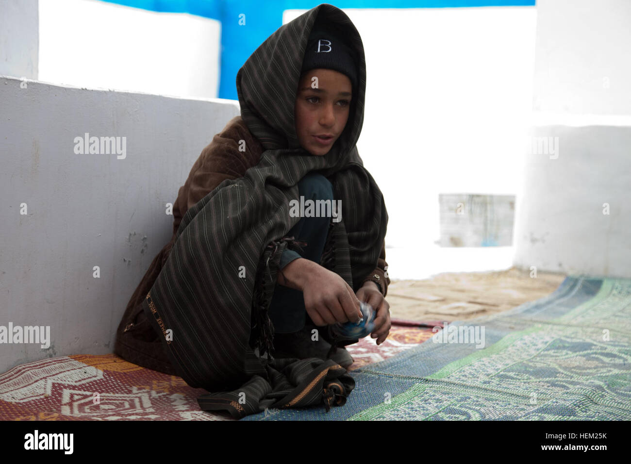 Un bambino gioca con una palla al centro della donna al di fuori della posizione di avanzamento Base Operativa Pasab, provincia di Kandahar, Afghanistan, 02 febbraio, 2012. (U.S. Esercito foto di Spc. Kristina Truluck, 55th Signal Company (COMCAM)/RILASCIATO) Centro per le donne a Kandahar 120202-A-VB845-014 Foto Stock