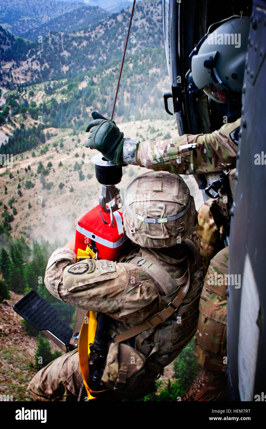 Stati Uniti Army Spc. Terry mulini di Brandon, Miss., tira U.S. Il personale dell'esercito Sgt. Ryan Stumpff, Fort Bragg, N.C., in un Black Hawk medevac elicottero 4 Luglio in provincia Khowst, Afghanistan. Stumpff, una quarta BCT, XXV divisione di fanteria militare di Fort Richardson, Alaska è stato intrecciato su di una scogliera stretta mentre scappava un nemico in agguato, richiedendo Valkyrie medevac, un doppio stato Guardia Nazionale unità per eseguire un paranco pericolose estrazione sotto il fuoco nemico durante la navigazione di un terreno pericoloso. Stumpff era stato colpito alla testa da un nemico di insorti, ma ha subito solo una ferita superficiale come la pallottola è passata th Foto Stock