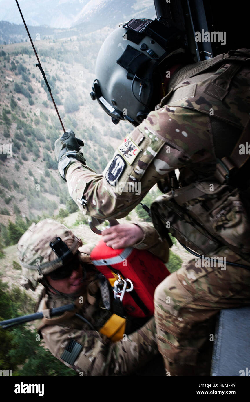 Stati Uniti Army Spc. Terry Mills, di Brandon, Miss., tira U.S. Il personale dell'esercito Sgt. Ryan Stumpff, Fort Bragg, N.C., in un Black Hawk medevac elicottero 4 Luglio in provincia Khowst, Afghanistan. Stumpff era arenati su una scogliera stretta mentre scappava un nemico in agguato, richiedendo Valkyrie medevac, un doppio stato Guardia Nazionale unità per eseguire un paranco pericolose estrazione sotto il fuoco nemico durante la navigazione di un terreno pericoloso. Stumpff era stato colpito alla testa da un nemico di insorti, ma ha subito solo una ferita superficiale come la pallottola è passata attraverso la parte posteriore del suo casco, sfiorate la cima della sua testa e abbandonata throu Foto Stock