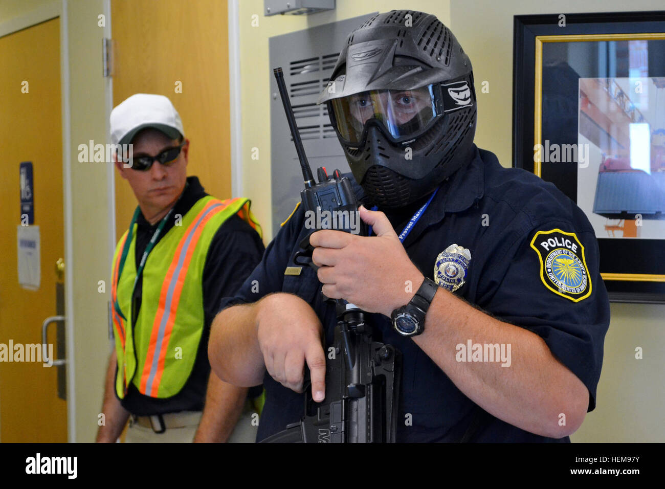 Larry Blackburn, un funzionario di polizia assegnato alla 596th brigata di trasporto, militare Ocean Terminal Sunny Point, N.C., fornisce un report sulla situazione durante un tiratore attivo scenario come Tony Casella, un esercizio osservatore/controller, orologi lo scenario si distendono. Casella, chi è assegnato per gli Stati Uniti Esercito Accademia di polizia a Fort Leonard Wood, Mo., era uno dei più esperti in materia chiamato a sostenere l'esercizio. Lo scenario è stato una delle decine di eventi che si sono svolti durante il punto Defender 2012 esercizio 20-23 Agosto a MOTSU. Punto Defender è un militare di distribuzione superficiale e Distrib Foto Stock