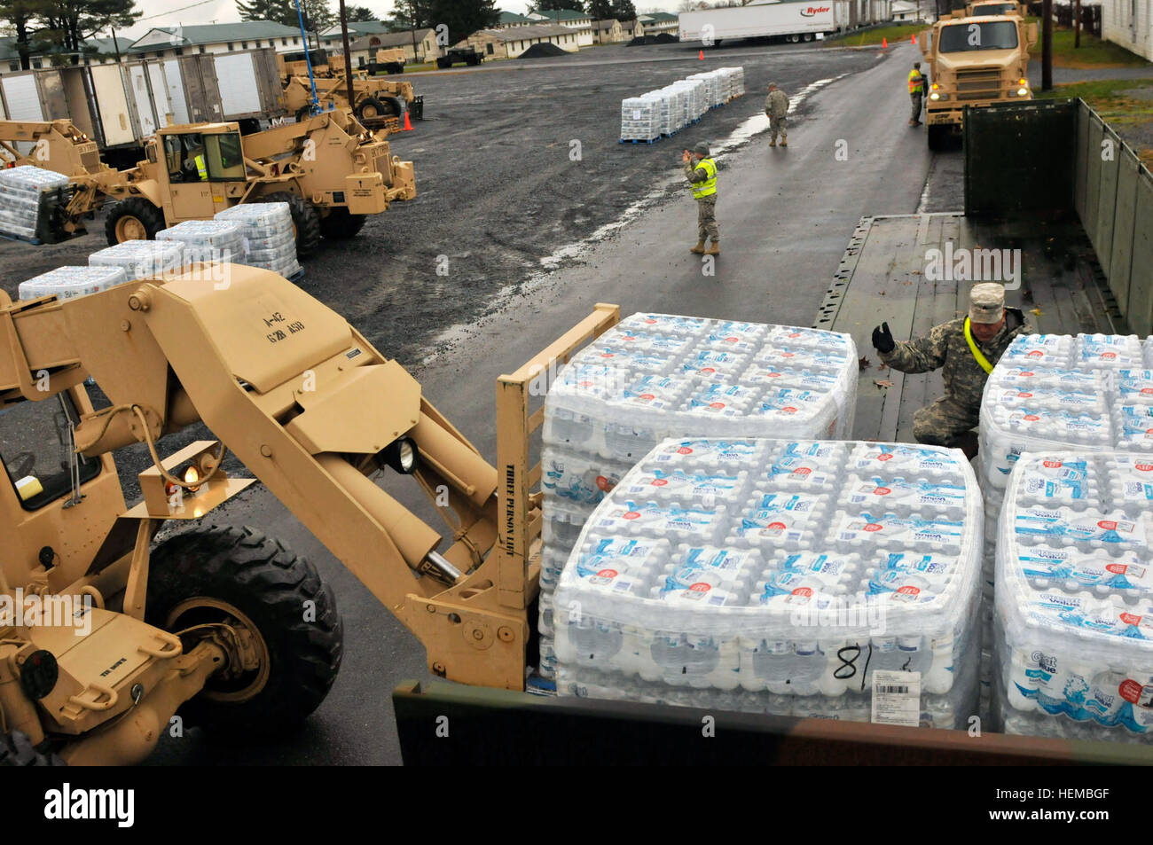 Sgt. Jorge Aviles, leader di un team per la 131Transportation Company, una unità della Pennsylvania esercito Guardia Nazionale e un Woodlynne, N.J. native, dirige il carrello driver utilizzando segnali a mano sul posizionamento del pallet di acqua sul rimorchio del suo M915A5Freightliner a Fort Indiantown Gap, Pa, il 31 ottobre 2012. Acqua lungo con casi di pasti pronti a mangiare sono stati caricati su di loro camion a sostegno della comunità di Kintnersville, Pa. che aveva bisogno di cibo e acqua, ha detto. PA Guardia Nazionale offre a Kintnersville nell ora del bisogno 121031-A-IX878-116 Foto Stock