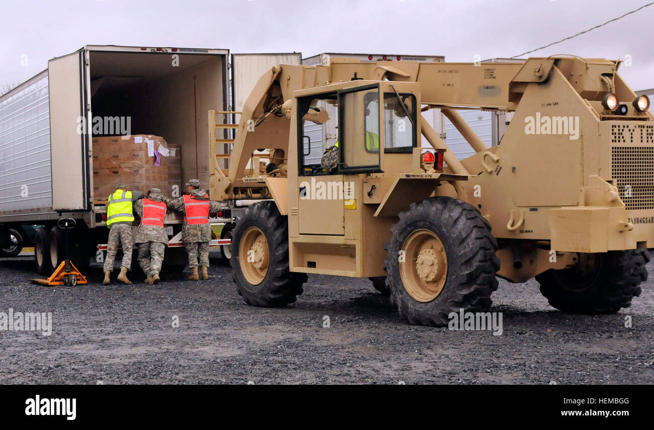 Più in Pennsylvania nazionale soldati di guardia torcere e ruotare un pallet di pasti pronti a mangiare per renderla accessibile per il carrello a Fort Indiantown Gap, Pa., Ottobre 31, 2012. Con il tempo vola su richiesta da una comunità per l acqua e il cibo, Soldati tutti si sforzano di ottenere il trailer del 131Transportation Company caricato e il camion su strada. PA Guardia Nazionale offre a Kintnersville nell ora del bisogno 121031-A-IX878-167 Foto Stock