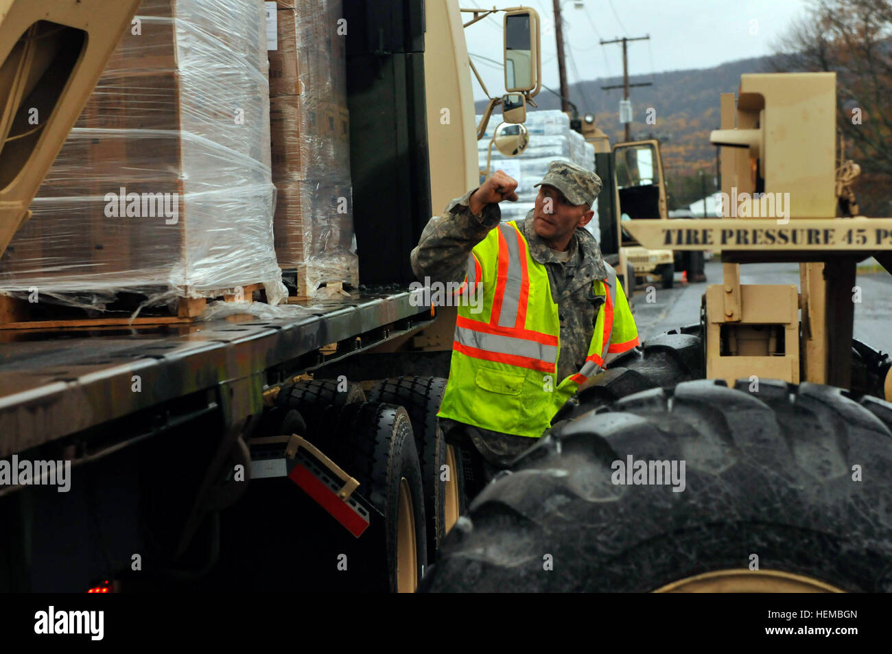 Sgt. Giovanni Ferrari, cantiere sottufficiale, e un Lancaster, Pa. nativo, fermare i segnali al conducente del carrello elevatore a caricare un altro pallet di pasti pronti a mangiare sul rimorchio di 131Transportation Company M19A5 Freightliner a Fort Indiantown Gap, Pa., Ottobre 31, 2012. I pallet di acqua e MREs sono stati caricati su questi carrelli per essere consegnato a Kintnersville, Pa. dalla richiesta della Pennsylvania Emergency Management Agency per il sostegno alle comunità dopo l'uragano di sabbia. PA Guardia Nazionale offre a Kintnersville nell ora del bisogno 121031-A-IX878-224 Foto Stock