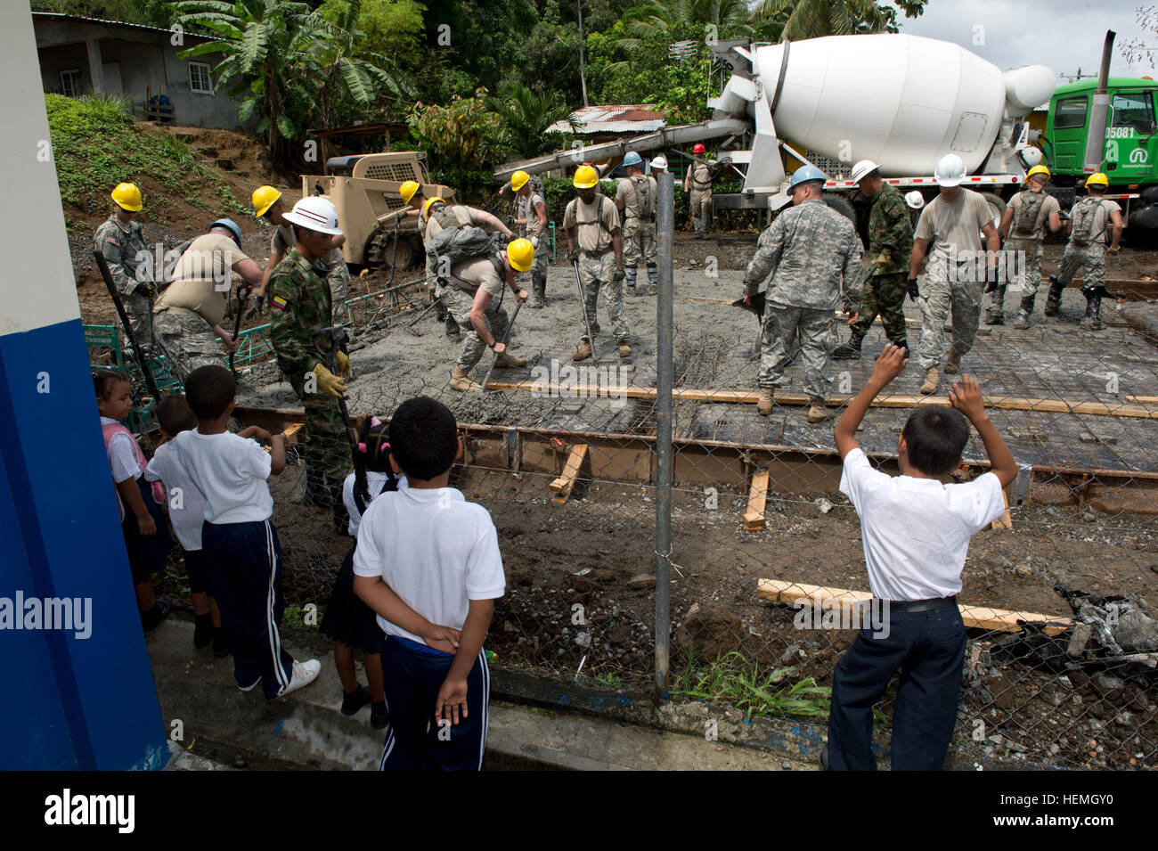 Bambini panamense guardare dalla loro scuola come Stati Uniti Esercito e esercito colombiano soldati diffusione concreto per una fondazione per una clinica di Achiote, Panama, durante la oltre l'orizzonte esercitare il 17 aprile 2013. Al di là dell'orizzonte è un U.S. Comando sud-sponsorizzato, U.S. Esercito sud-pianificato e portato annuale di aiuti umanitari e di assistenza civica di esercizio che prevede la costruzione e l'assistenza medica alle nazioni partner in tutta l'America centrale e del Sud e nei Caraibi. L'esercizio avviene generalmente in zone rurali e costituisce un componente importante del militare degli Stati Uniti a livello regionale gli sforzi di impegno di un Foto Stock