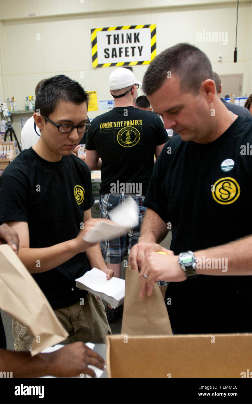 Candidato ufficiale di Alessandria Ysassi (sinistra), di Seminole, Okla., aiuta a costruire il sacco al sacco durante una comunità di un progetto di servizio a livello regionale Food Bank of Oklahoma. Ysassi è un membro dell'esercito Oklahoma Guardia nazionale responsabile della scuola del candidato di classe 58. La classe ha trascorso un giorno a livello regionale Food Bank aiutando il personale con un certo numero di compiti includono la preparazione di pranzi a sacco per i bambini attraverso la metropolitana. Nella sua carriera civile, Ysassi è un tecnico di servizio con Stanley vaporizzatore. OCS Progetto di servizio 130718-A-BB392-086 Foto Stock