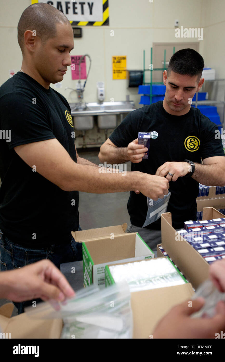 Candidato ufficiale di Albert Valle (sinistra), di Lawton, Okla., aiuta a collocare un drink scatola in uno snack pack per i bambini durante un servizio alla comunità il progetto presso il cibo regionale Bank of Oklahoma. La Valle è un membro dell'esercito Oklahoma Guardia nazionale responsabile della scuola del candidato di classe 58. La classe ha trascorso un giorno a livello regionale Food Bank aiutando il personale con un certo numero di compiti includono la preparazione di pranzi a sacco per i bambini attraverso la metropolitana. Nella sua carriera civile, la Valle è un funzionario di correzioni con l'Oklahoma Dipartimento di correzioni. Egli è stato un membro dell'esercito Oklahoma la Guardia Nazionale per circa un Foto Stock