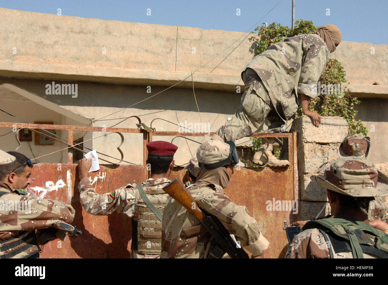 Un membro dell'esercito iracheno si arrampica su una porta bloccata in Riyadh, Iraq, Sett. 22, durante un pattugliamento congiunto con la Società Delta, 2° Battaglione, 27° Reggimento di Fanteria, 3° Brigata Team di combattimento, XXV divisione di fanteria. Riyadh 61849 Patrol Foto Stock