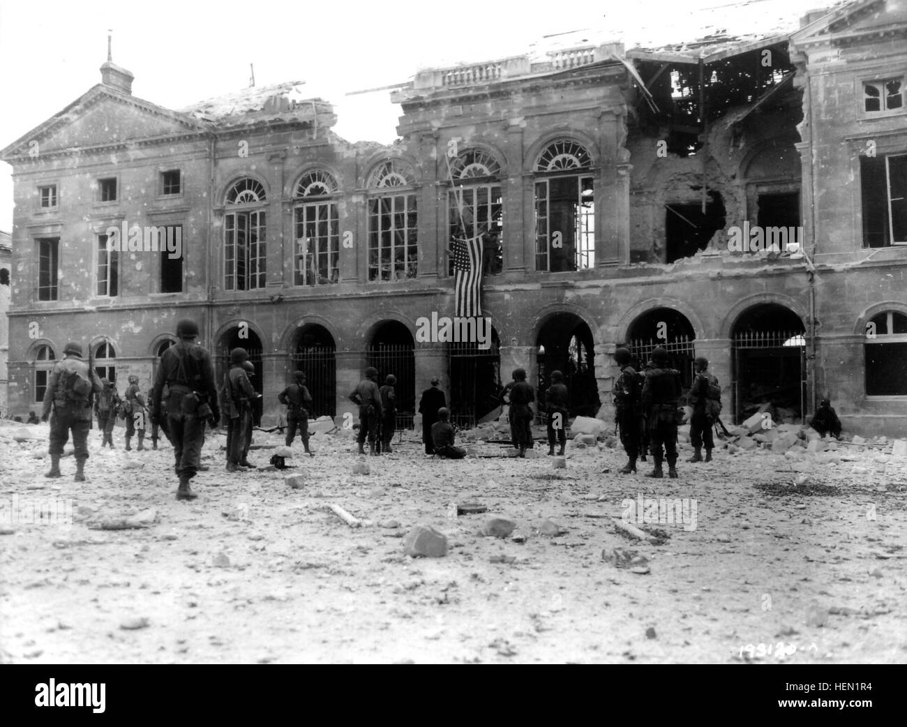 Le 20 août 1944, des GI'S viennent d'accrocher onu drapeau américain sur la facciata de l'Hôtel de ville, détruit en présence du Maire d'Argentan M. Yves Sylvestre et du colonel Harry D. Mac Hugh commandant du 318Reggimento di Fanteria de la 80th noi divisione di fanteria. Una gauche onu medic, voir casque et brassard de la Croix-Rouge. Cette séquence un été filmée : http://www.flickr.com/photos/mlq/4340454436/ http://www.flickr.com/photos/mlq/4358874991/ voir au centre de la foto, cameraman onu à genoux : voir la p000432 en gros plan: http://www.flickr.com/search/?w=58897785@N00&q=p000431 Quelques années Foto Stock