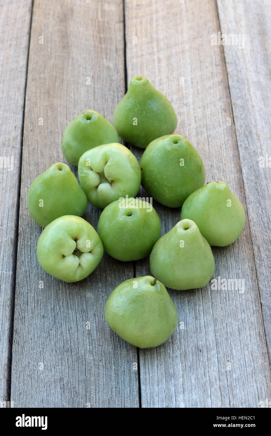 Appena raccolto Syzgium samarangense o noto come cera Jambu o campana mele isolata contro lo sfondo di legno Foto Stock