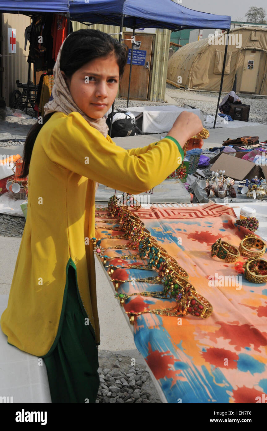 Una ragazza afgana pause per la telecamera come ella imposta bejeweled gioielli presso le donne afghane's Bazaar, presso le donne afghane's Bazaar, nuovo composto di Kabul, Afghanistan, su Ott. 23, 2013. Le donne afghane e i bambini venuti a NKC per vendere casa-spun artigianato e altro ancora, il bazar è una opportunità per le donne e i bambini per aiutare a sostenere le loro famiglie attraverso la vendita di souvenir afghano. Chitter-chatter di giovani I bambini riempiono l'aria come nuovo composto di Kabul, le donne afgane%%%%%%%%E2%%%%%%%%80%%%%%%%%99s Bazaar molle alla vita 131023-A-WQ129-009 Foto Stock