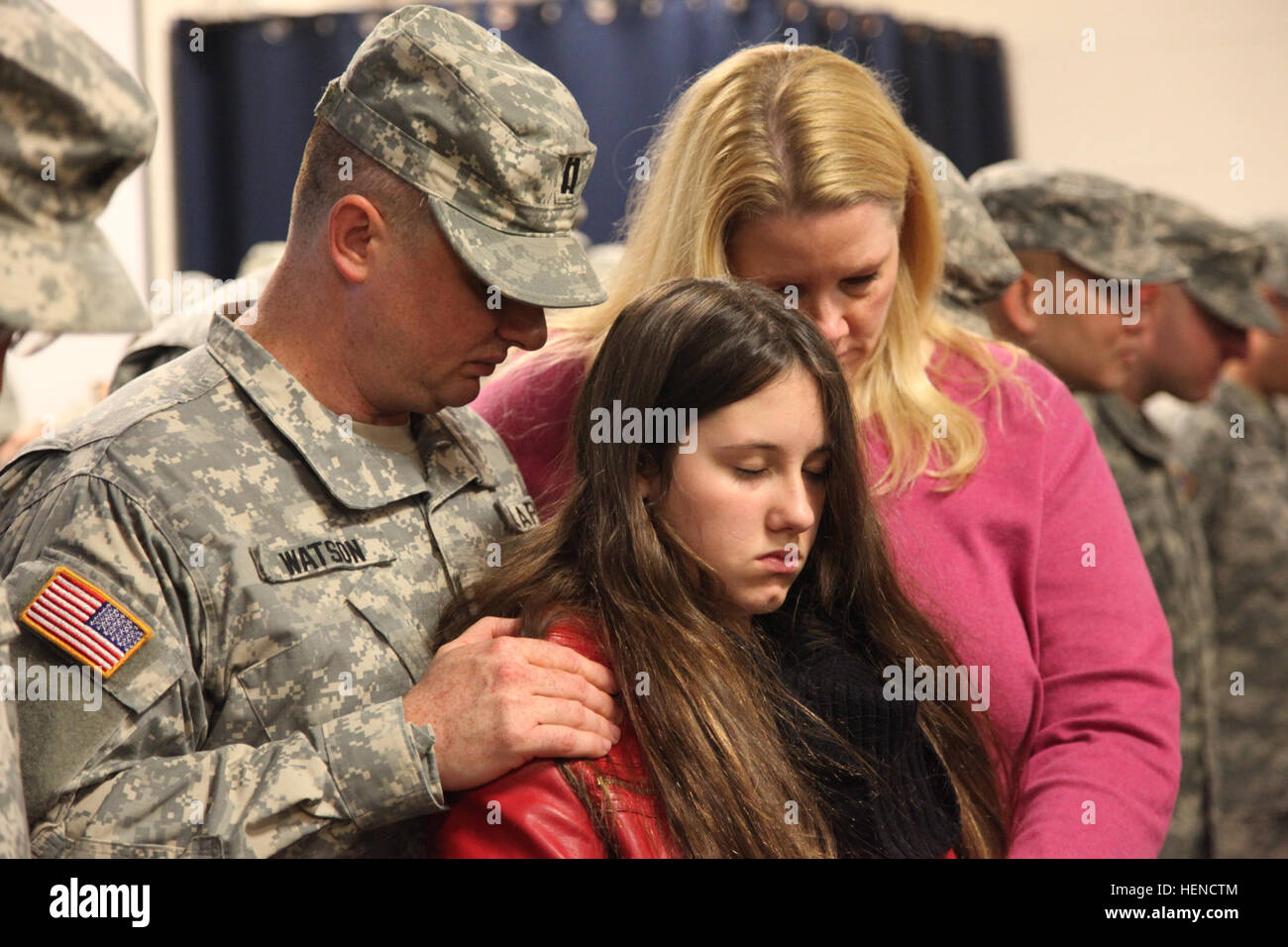 Stati Uniti Esercito Capt. Matthew Watson, assegnato al segnale 335a comando (teatro), il distacco 34, prega con i membri della sua famiglia durante una cerimonia di distribuzione in Drill Hall, 335Headquarters Building, East Point, Ga., Marzo 14, 2014. Questi soldati sono la distribuzione in Afghanistan e Kuwait per sostenere l'Operazione Enduring Freedom. (U.S. Esercito foto di Sgt. Austin Berner/ Rilasciato) 335a comando di segnalazione (Teatro) Distacco 34 Cerimonia di distribuzione 140314-A-BZ540-040 Foto Stock