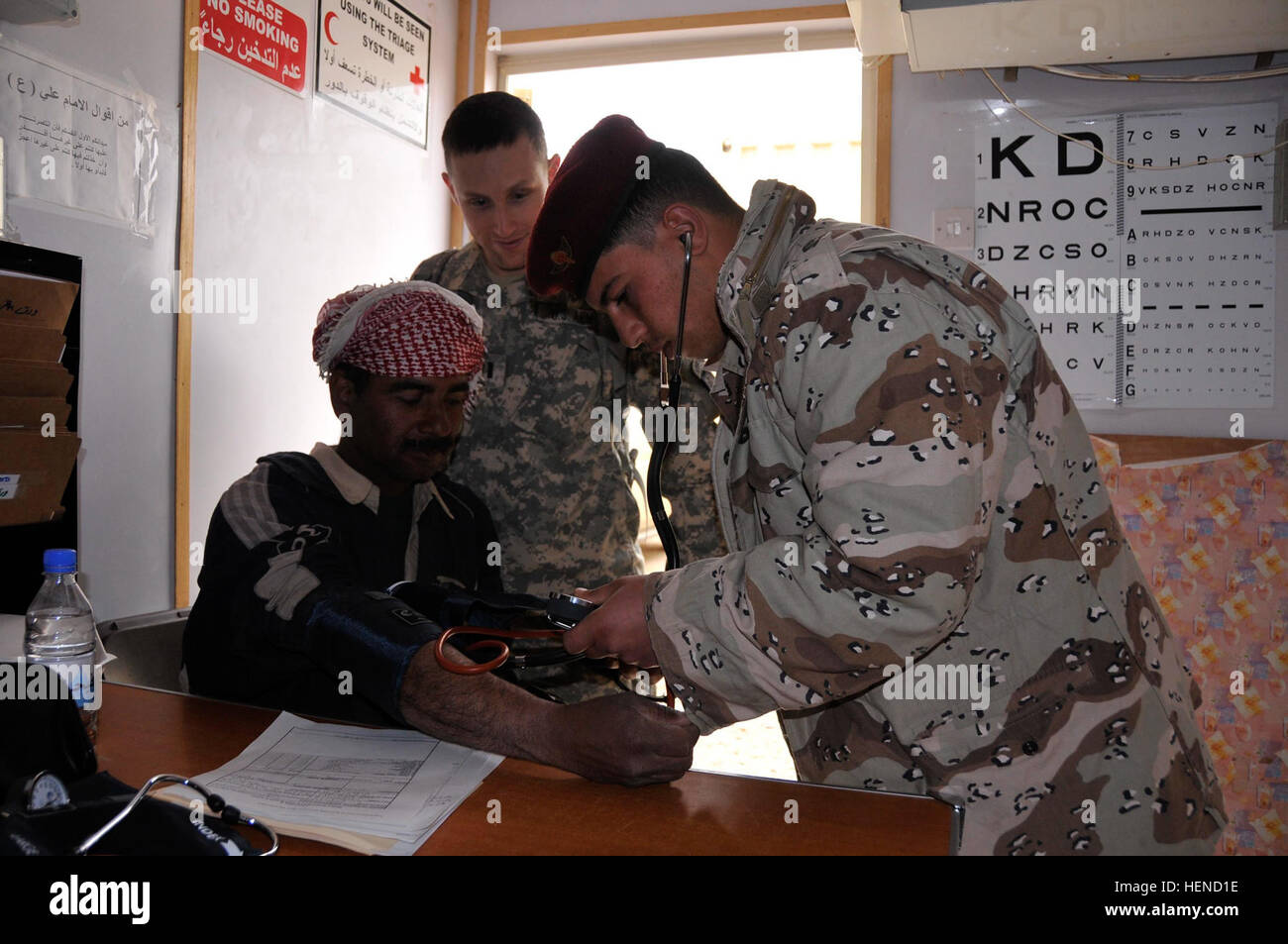 1Lt. Damien Barrineau, medici Assistant per il secondo battaglione, campo 320reggimento di artiglieria, 1° Brigata Team di combattimento, 101st Airborne Division (Air Assault), orologi come un esercito iracheno medic controlla la pressione del sangue di un figli dell Iraq stati durante il funzionamento le sfere deputati (Militare arruolamento stazione di lavorazione) durante il medico di fase di screening, il 26 febbraio, a inoltrare una base operativa O'Ryan, Iraq. L'2-320th lontano congiuntamente pianificato ed eseguito il funzionamento con il governo iracheno nelle speranze di transizione le migliaia di SoIs entro la loro area di operazioni in sicurezza irachena Foto Stock