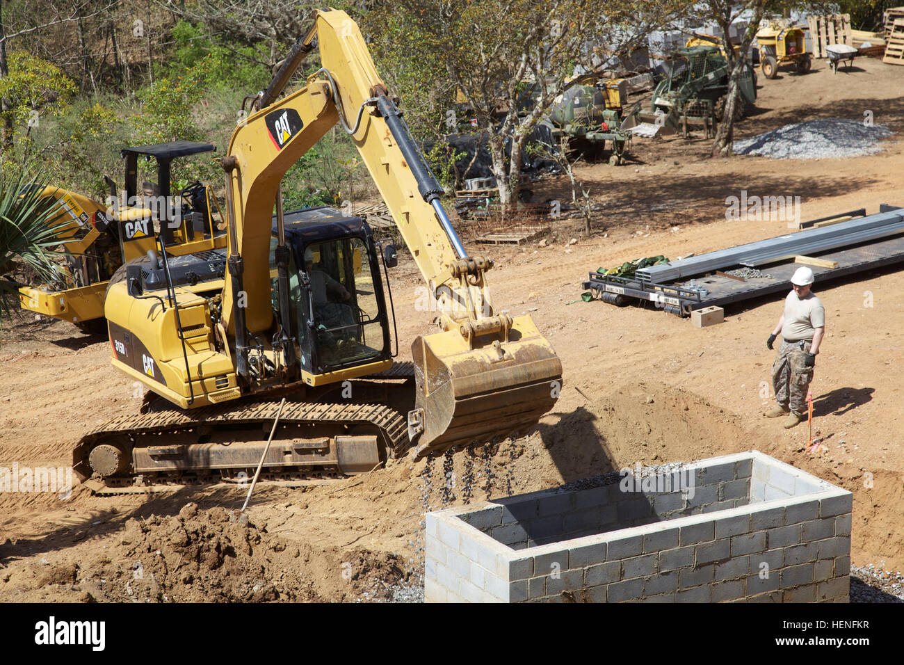 Gli ingegneri dell'esercito statunitense versano ghiaia intorno a una fondazione di serbatoi settici utilizzando un escavatore CAT 315D durante Beyond the Horizon a Chiquimula, Guatemala, sostenendo gli sforzi umanitari e di assistenza civica, inclusi programmi medici, dentistici e civici. Foto Stock