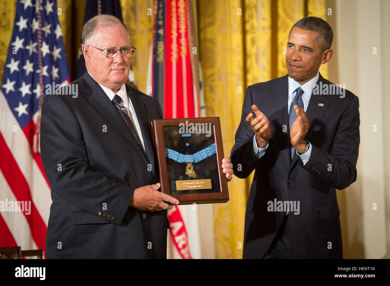 Il presidente Barack Obama awards medaglia d'onore dell'esercito Spc. 4 Donald P. Sloat, accettando il suo nome è il suo fratello il dottor Bill Sloat nella Sala Est della Casa Bianca, Sett. 15, 2014. Sloat si distinse mentre serve come una macchina gunner con il 1° Reggimento di Fanteria, 196th luce brigata di fanteria, Americal Division, durante le operazioni di combattimento contro un nemico armato nella Repubblica socialista del Vietnam. La mattina di gennaio 17, 1970, Sloat's squad spostato fino alla cima di una collina nella formazione di file, quando il soldato di piombo è scattato un filo collegato a una bomba a mano trappola, istituito dalle forze nemiche. Quando il Foto Stock