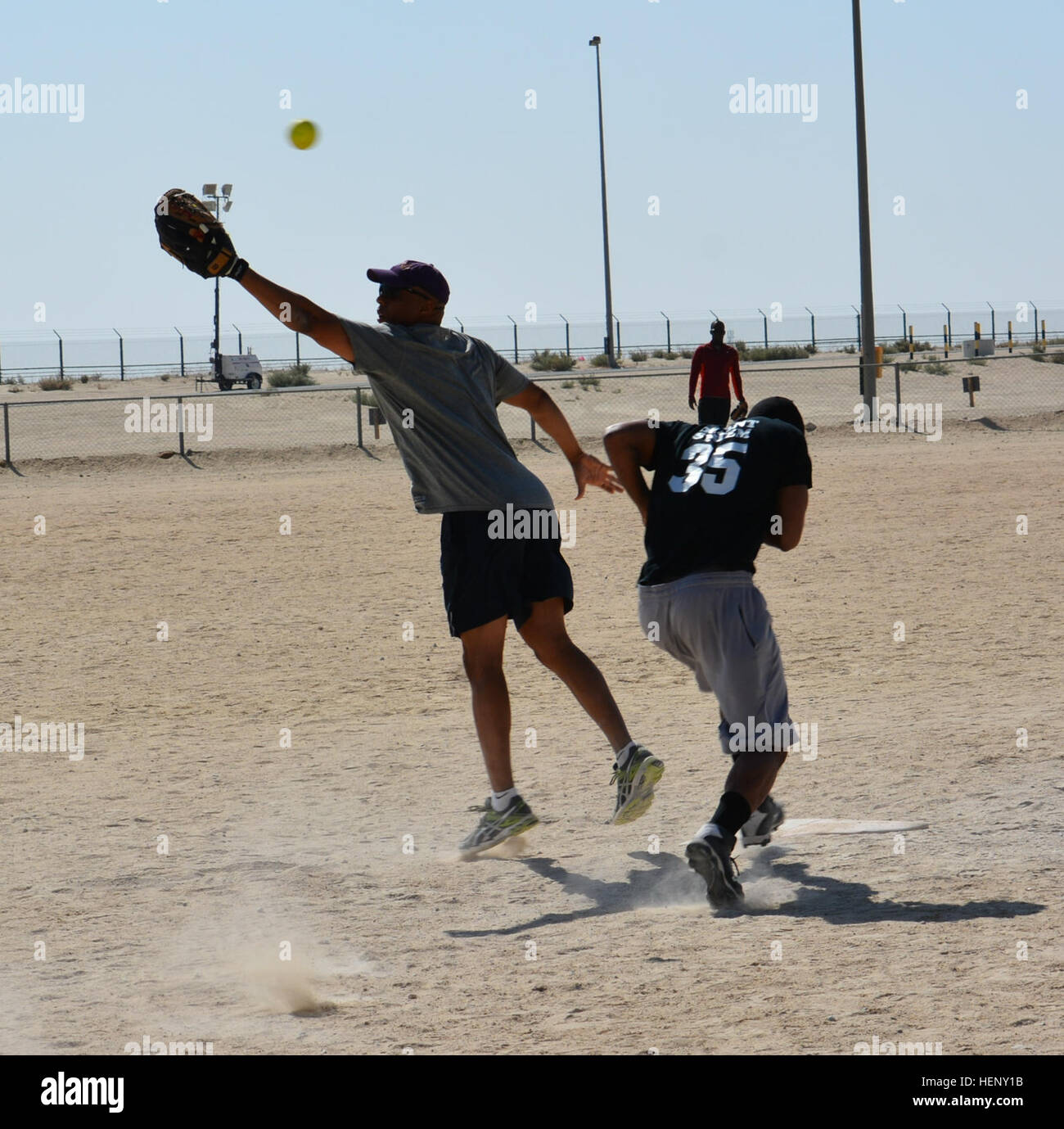 Numero 35 Sgt. D'shaun Howard, una specialista risorse umane per il terzo supporto brigata, anatre durante la corsa al primo di base come la palla è finita generata durante un passo lento softball game a Camp Arifjan, Kuwait, nov. 2. Howard, nativo di nuovo Madrid, Mo., aveva un RBI su questo gioco. Provider di sicuro alla prima base 141102-A-KX461-045 Foto Stock