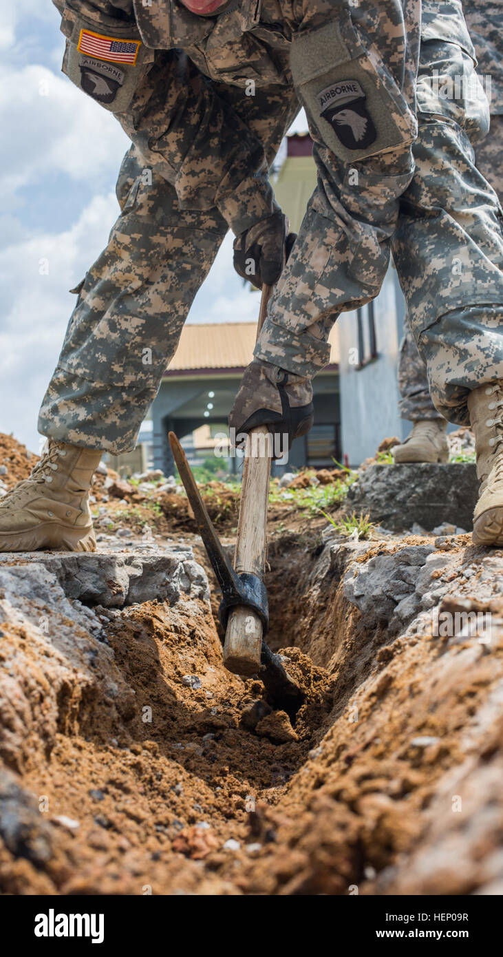 Un soldato con il Comando interforze - Regno Assistenza, gallerie fuori un percorso per cavi a fibra ottica per collegare il sindaco cella nov. 22, 2014, presso Barclay Training Centre di Monrovia, Liberia. Egli e altre saldature assegnato a JFC-UA hanno lavorato insieme per estendere la U.S. Africa il comando dei servizi di rete a supporto del funzionamento Regno Assistenza, rendendo più facile per la comunicazione. Regno assistenza è un Dipartimento della Difesa il funzionamento in Liberia per fornire la logistica, la formazione e il supporto tecnico di U.S. Agenzia per lo Sviluppo Internazionale-ha guidato gli sforzi per contenere il virus Ebola focolaio in western Foto Stock