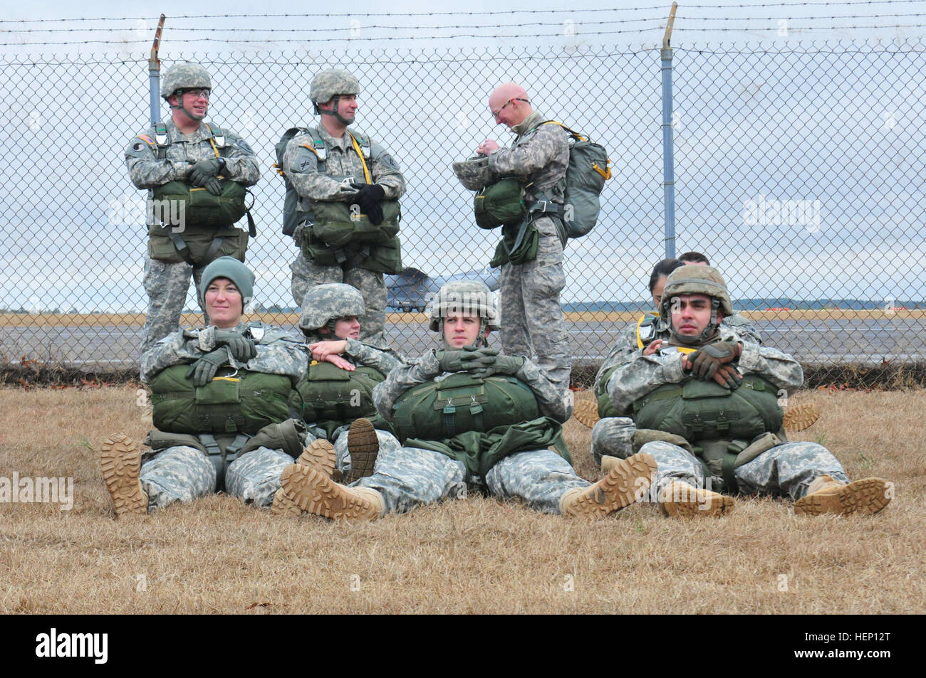Stati Uniti Paracadutisti dell'esercito attendere pazientemente di velivoli di carico per la formazione in volo durante il XVII annuale di Randy Oler Memorial il funzionamento del giocattolo Drop, ospitato dalla U.S. Esercito degli affari civili e le operazioni psicologiche il comando (airborne), Dicembre 9, 2014, a Camp Mackall Army Air Field, N.C. Il funzionamento del giocattolo Drop è la più grande del mondo di combinata airborne operazione con sei partner alleati nazione paracadutisti che partecipano e soldati consente la possibilità di aiutare i bambini nel bisogno di ricevere giocattoli per le vacanze. (U.S. Esercito foto di Spc. Lisa Velazco) US Army paracadutisti di attendere pazientemente 141209-A-QW291-090 Foto Stock