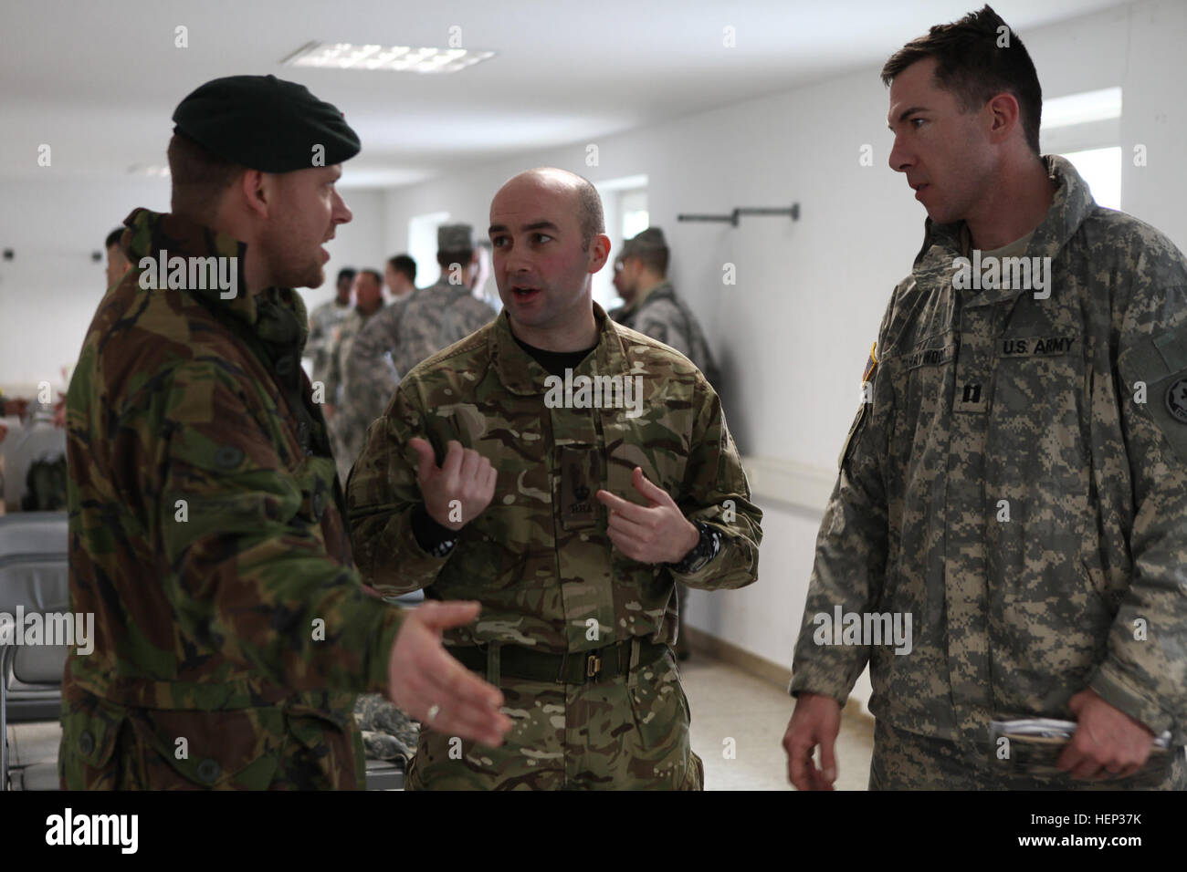 Stati Uniti Esercito Capt. Scott Haywood del 2° reggimento di cavalleria, destra, Royal Netherlands Army Capt. Ben, Kemper a sinistra del quarantaduesimo battaglione meccanizzato, xiii brigata meccanizzata e un soldato britannico del primo battaglione del reggimento di Mercian discutere una prova breve mentre si conduce una lotta contro le armi di prove durante l'esercizio Allied spirito presso la multinazionale comune disponibilità centro in Hohenfels, Germania, 22 gennaio 2015. Esercizio Allied spirito include più di duemila partecipanti provenienti da Canada, Ungheria, Paesi Bassi, Regno Unito e Stati Uniti Allied spirito è esercizio di tattica di interoperabilità e di collaudo co sicura Foto Stock