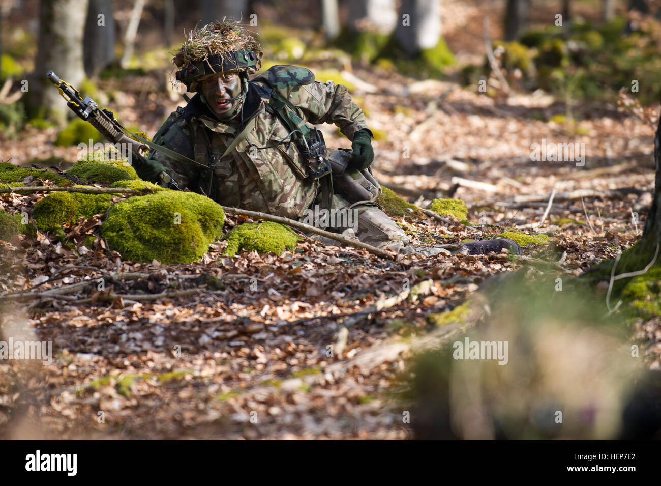 Un British cadet dell'accademia militare reale Sandhurst grida per munizioni extra durante la valutazione finale e la convalida di formazione presso il Comune di multinazionale Centro Readiness in Hohenfels, Germania, 18 marzo 2015. Lo scopo della certificazione è di formare e valutare i cadetti sul processo decisionale, pianificazione, campo di competenze artigianali e le operazioni in un ambiente tattico al fine di preparare allievi ufficiali per la messa in servizio nell'esercito britannico. (U.S. Esercito foto di Sgt. 1. Classe Caleb Barrieau) Royal Military treni a JMRC 150318-A-WB953-477 Foto Stock