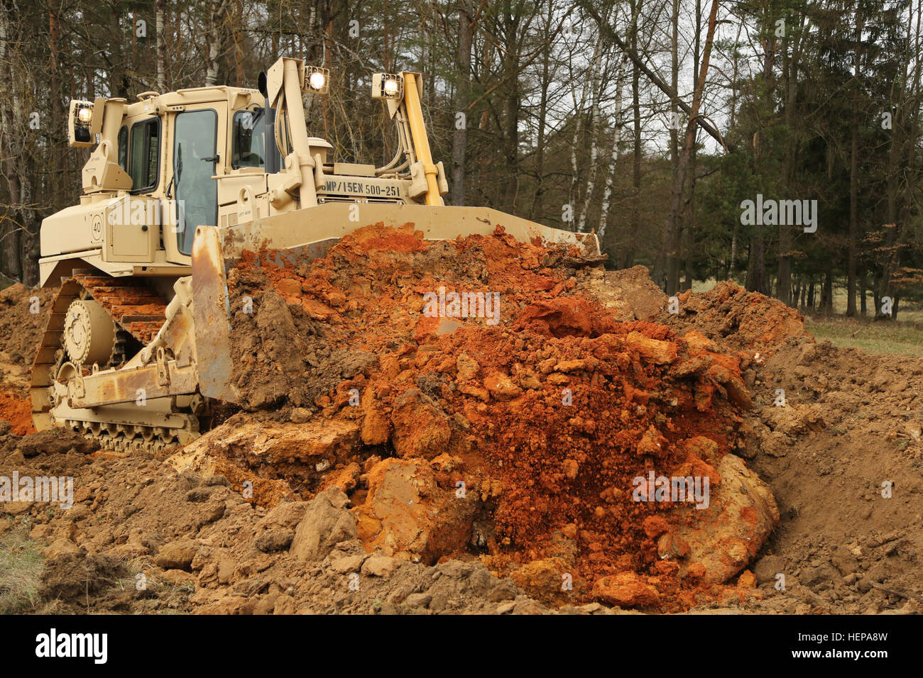 Un U.S. Soldato dell'esercito, del cinquecentesimo Engineer Company, ingegnere xv battaglione, XVIII Polizia Militare brigata, costruisce un serbatoio ostacolo con un bulldozer durante l'esercizio Saber Junction 15 presso l'U.S. Dell'esercito multinazionale comune disponibilità centro in Hohenfels, Germania, 12 aprile 2015. Saber Junction 15 prepara la NATO e partner le forze della Nazione per offensiva e difensiva e operazioni di stabilità e promuove l'interoperabilità tra i partecipanti. Saber Junction 15 ha più di 4.700 partecipanti provenienti da 17 paesi, per includere: Albania, Armenia, Belgio, Bosnia, Bulgaria, Gran Bretagna, Ungheria, Lettonia, Lithua Foto Stock